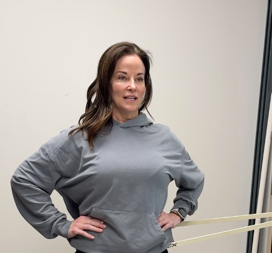 A woman with long hair and freckles is smiling for the camera.