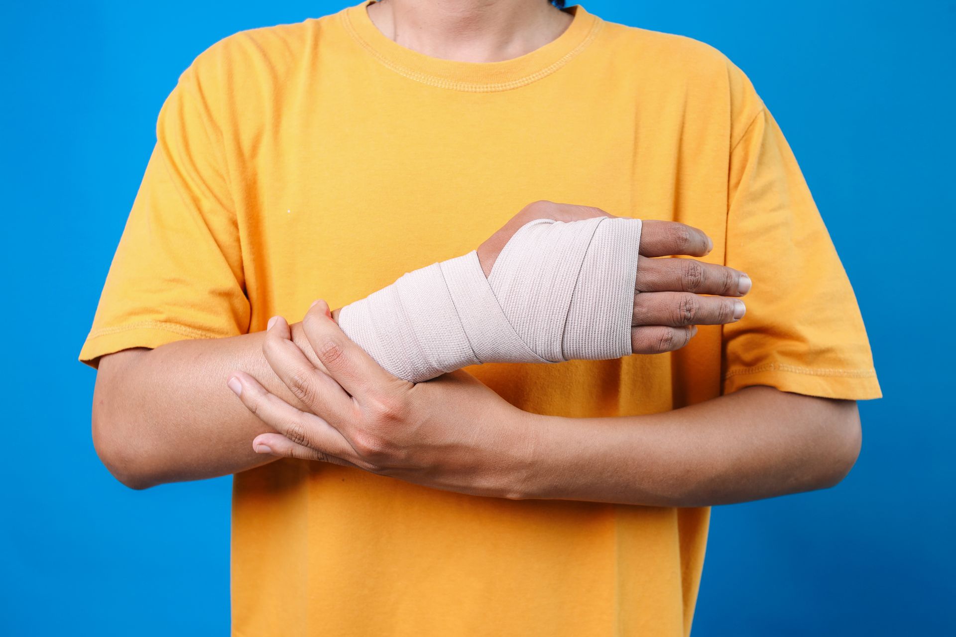 A man with a cast on his arm is holding his hands together.