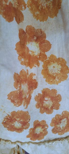 Orange flower prints on white fabric.