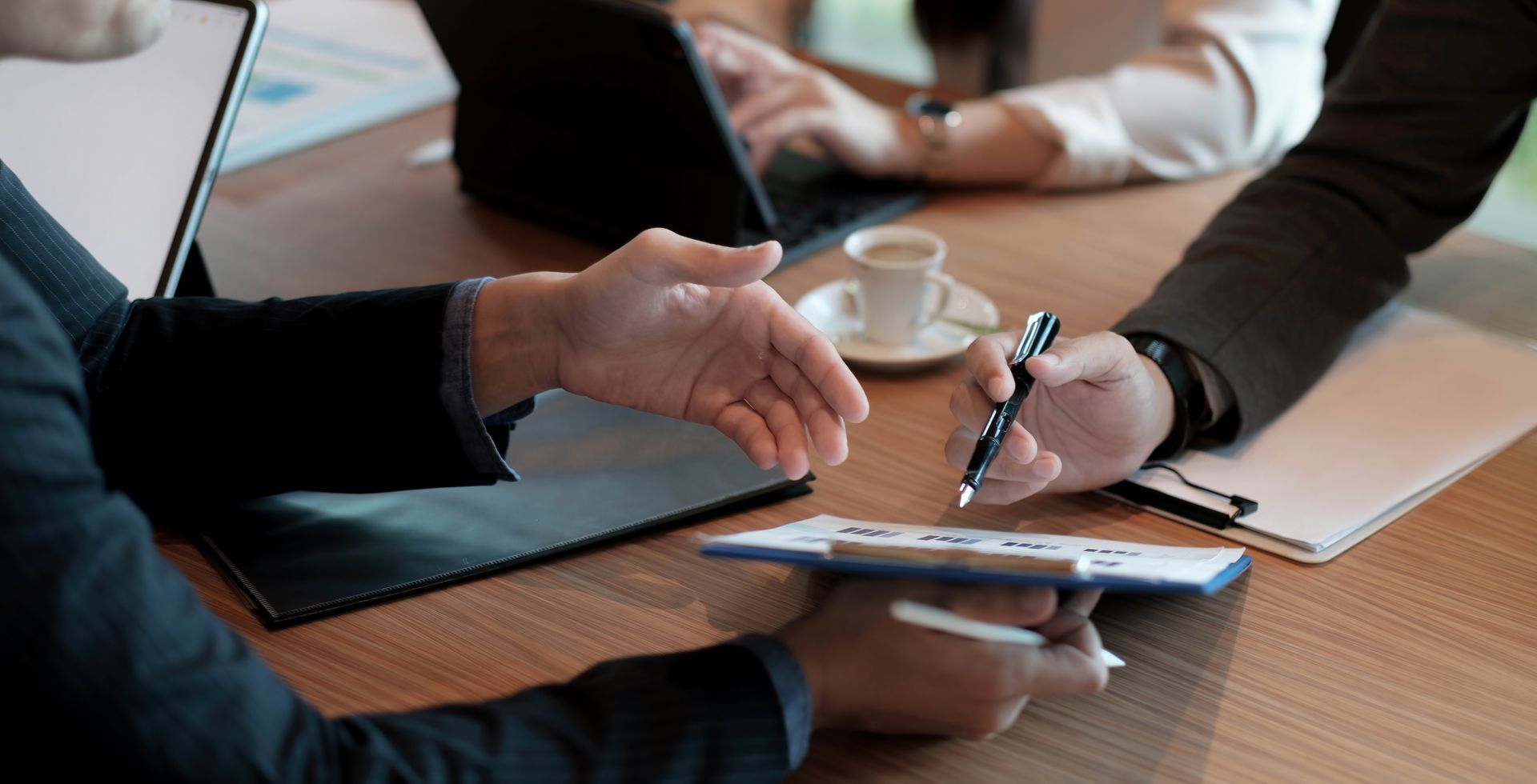 A group of people are sitting at a table signing a document.