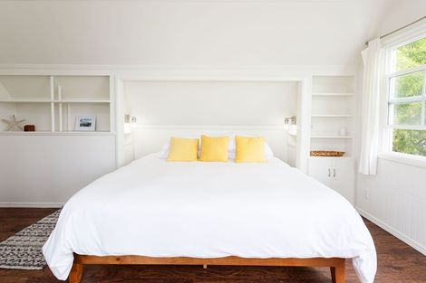A bedroom with a king size bed and yellow pillows.