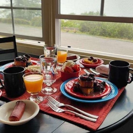 A table with plates of food and glasses of orange juice