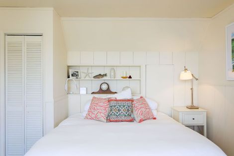 A bedroom with a bed , nightstand , lamp and closet.