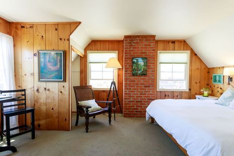 A bedroom with a bed a chair and a lamp