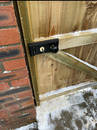 A close up of a wooden gate with a key in it.
