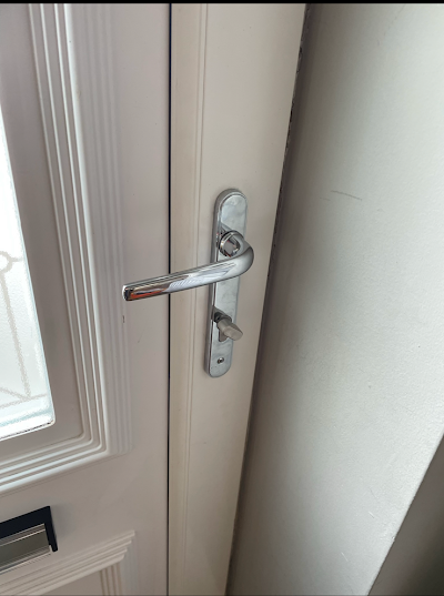 A close up of a door handle on a white door