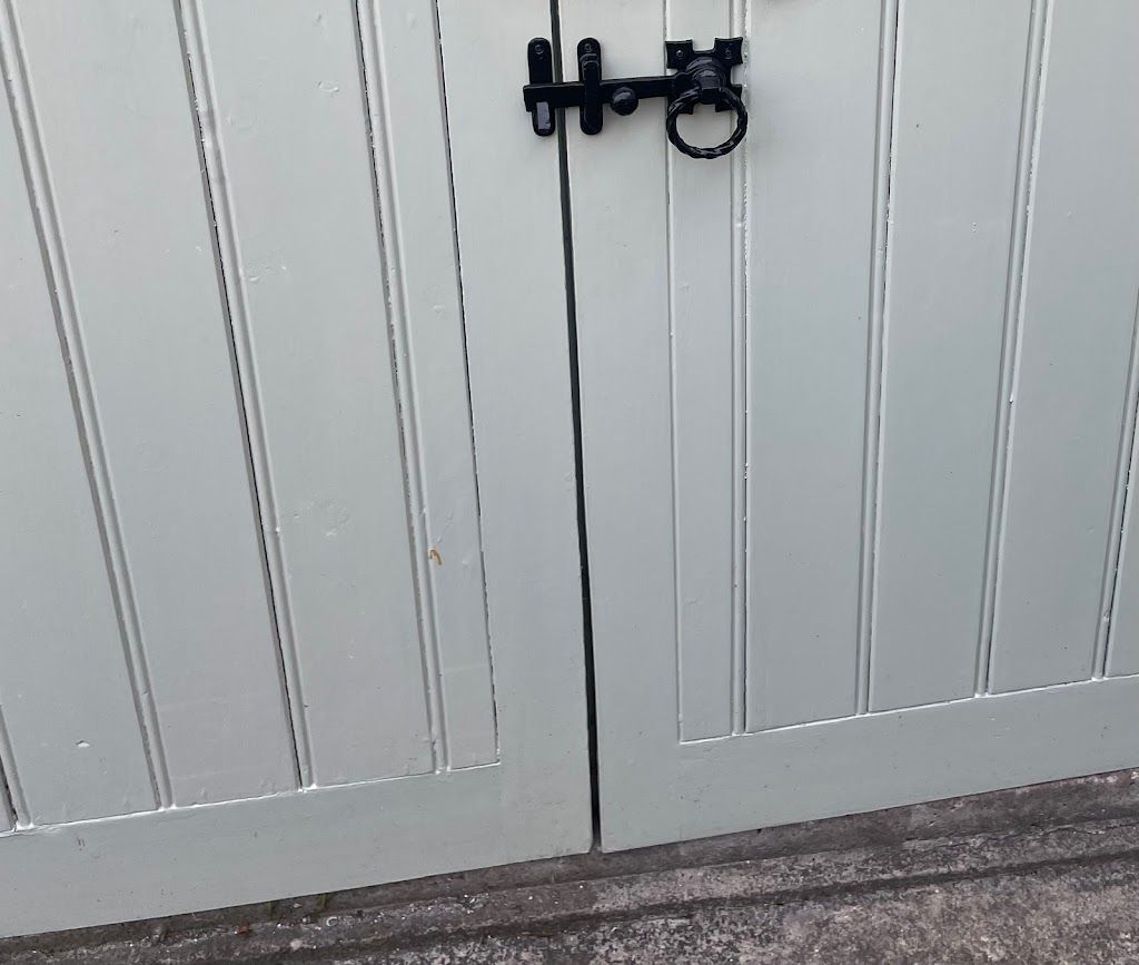 A white garage door with a black latch on it.