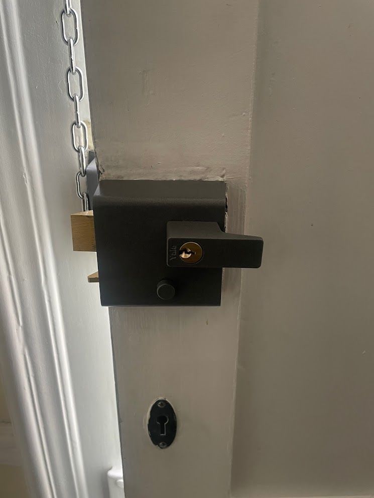 A close up of a door lock with a chain attached to it.
