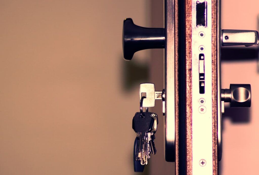 A close up of a door lock with keys in it.