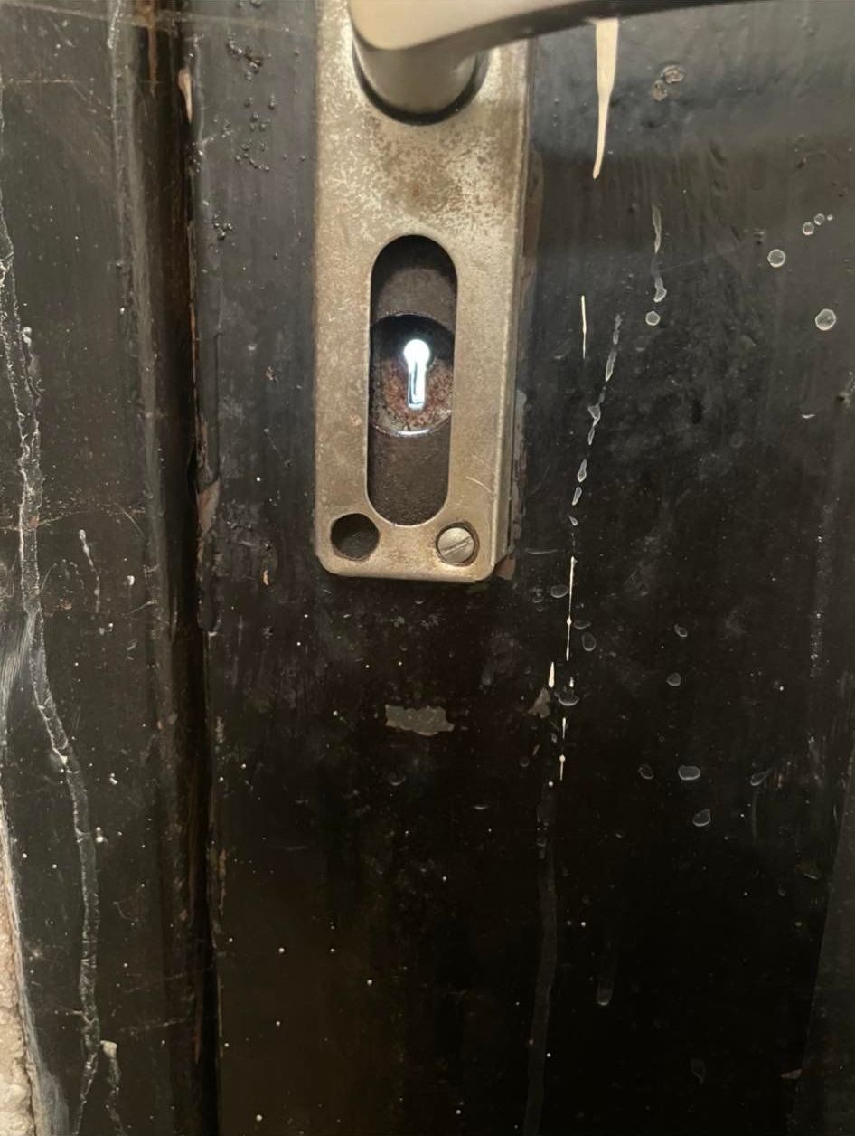 A close up of a door handle on a black door.