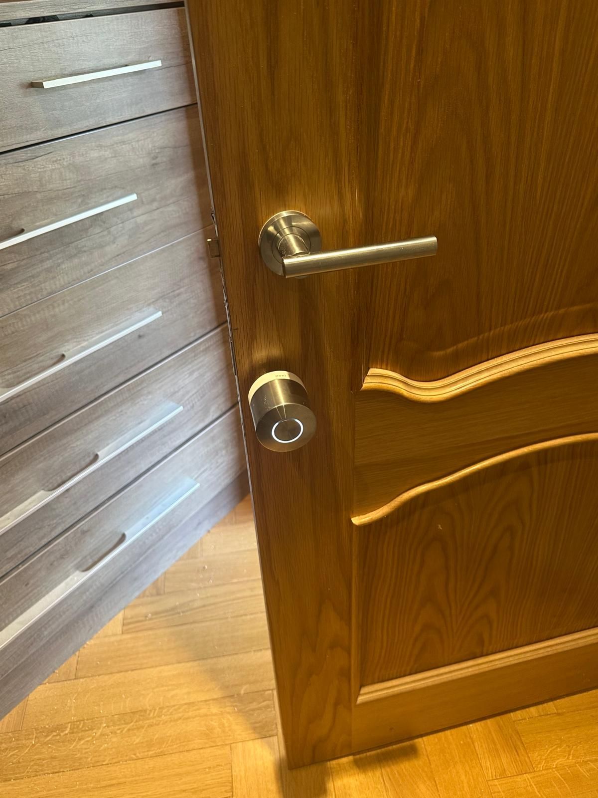 A person is fixing a door lock with a key.