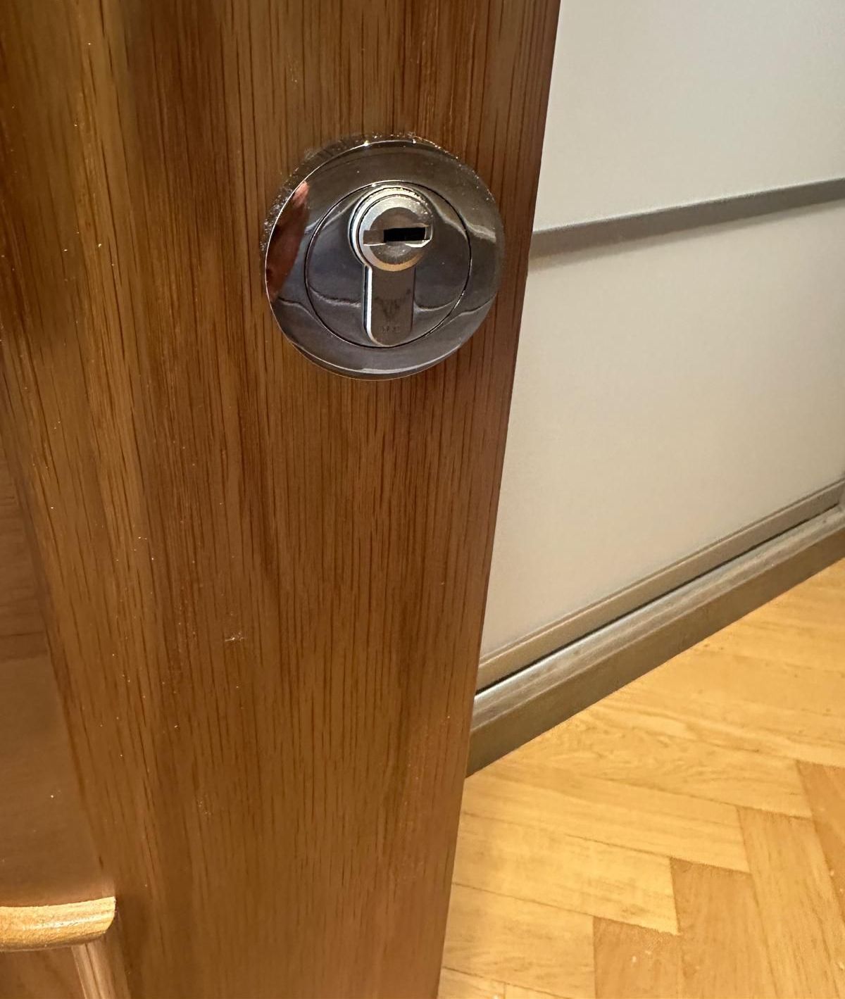 A close up of a door handle on a white door.