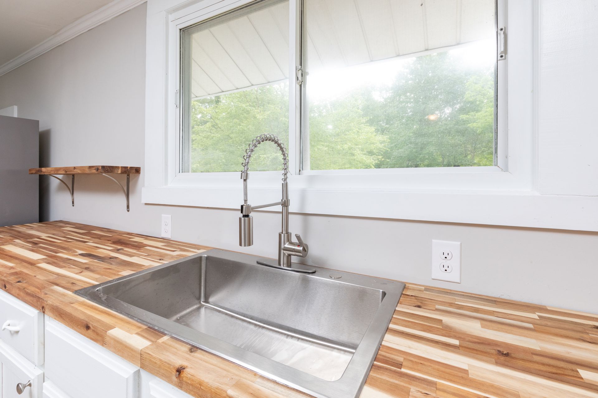 A modern kitchen features white cabinets and stone benchtops, creating a bright and clean aesthetic.