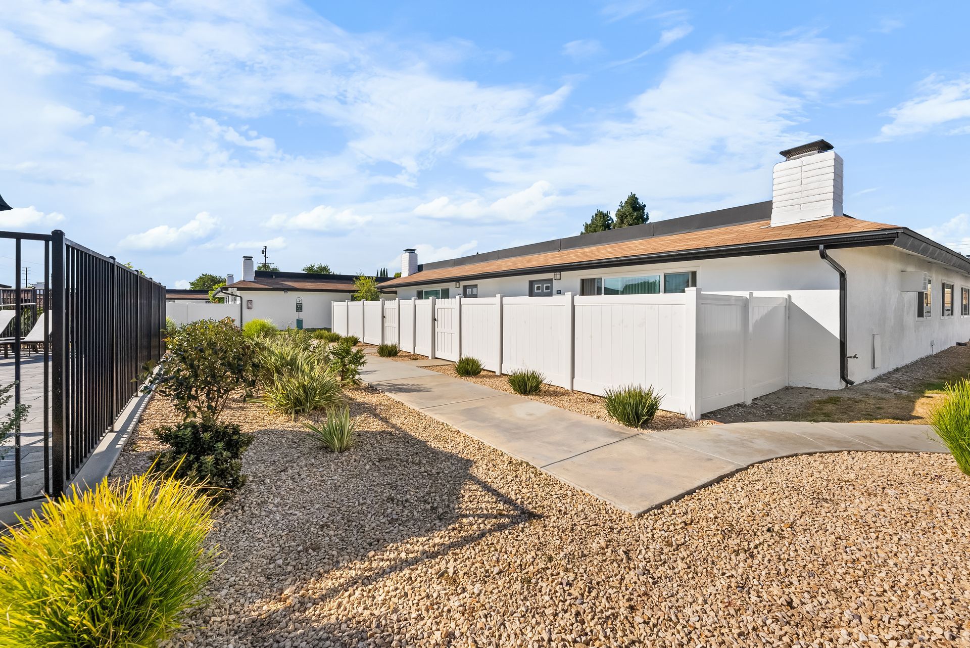 fenced patio with gravel and landscaping