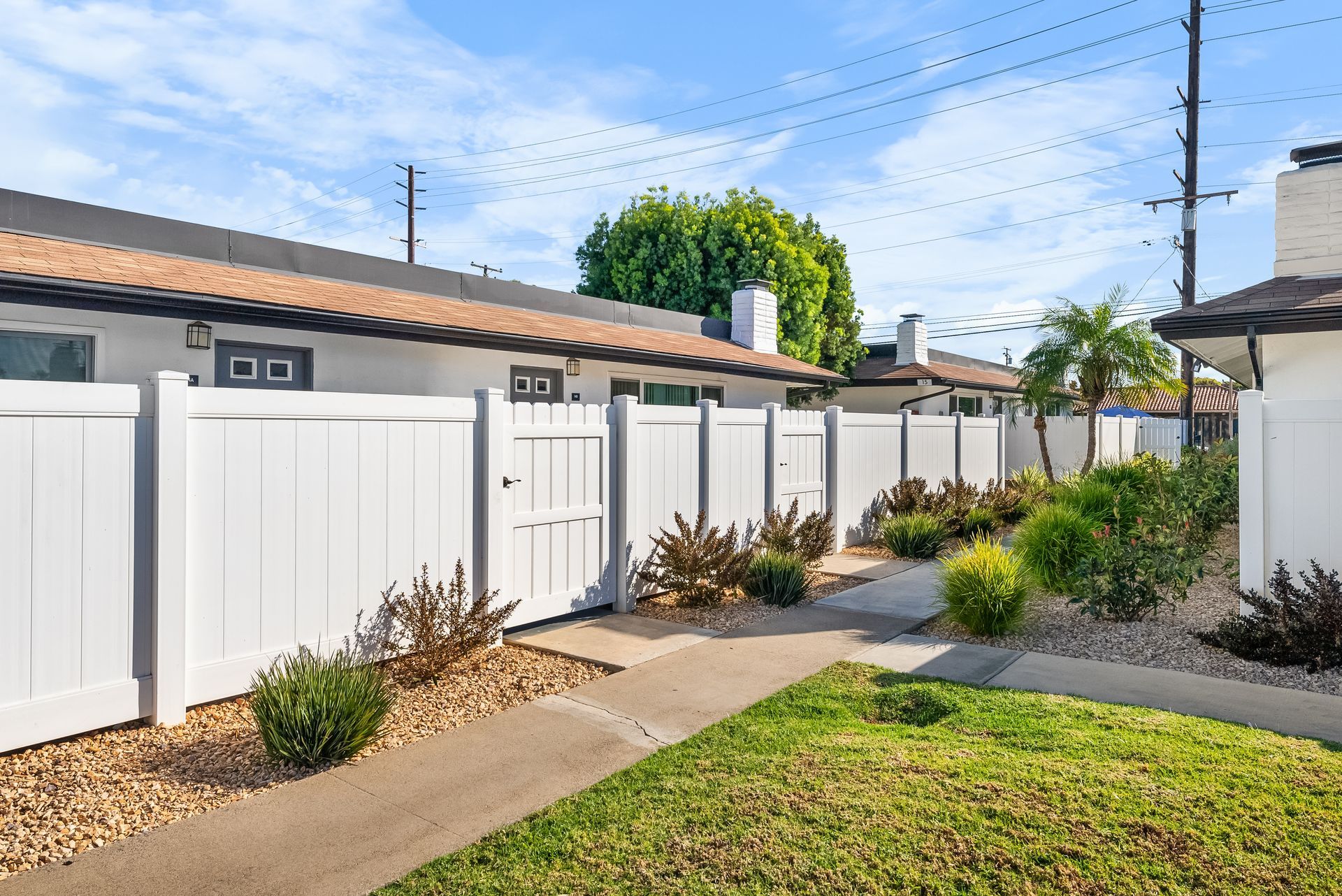 Exterior patio fence, grass, and sidewalk