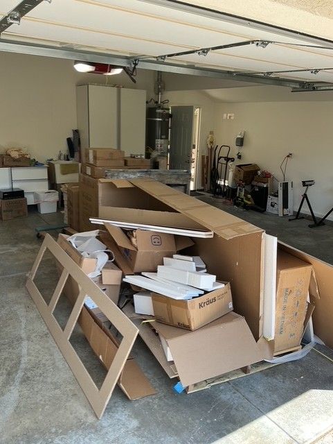 Cleanup King LLC - A cluttered garage with cardboard boxes and debris.