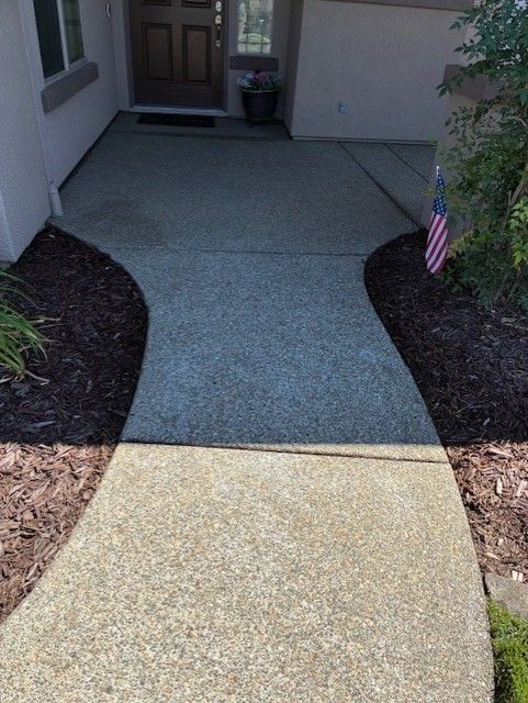 Cleanup King LLC - Concrete walkway leading to a front door, edged by dark mulch and landscaping.