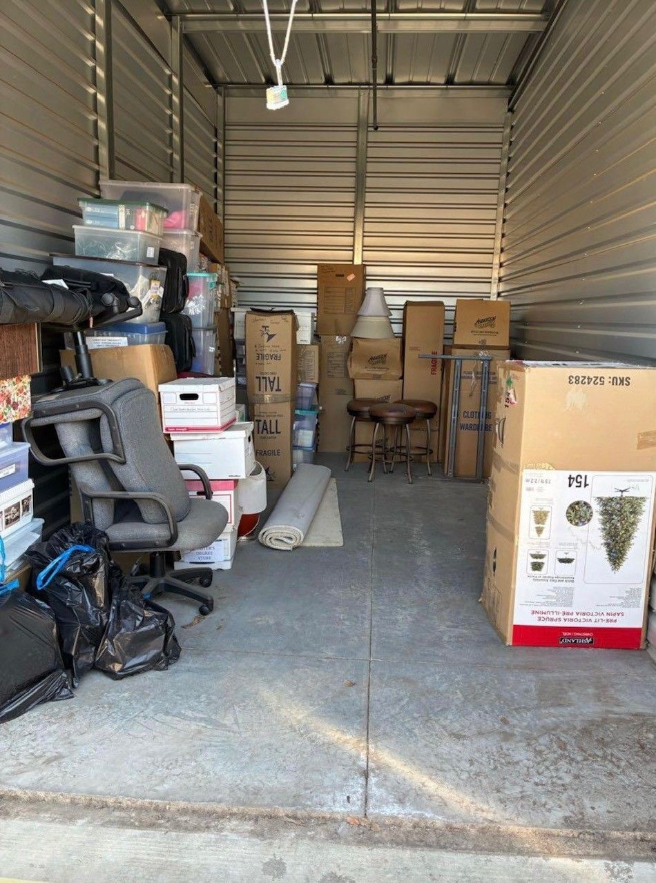 Cleanup King LLC - A storage unit filled with boxes, a chair, and various items.