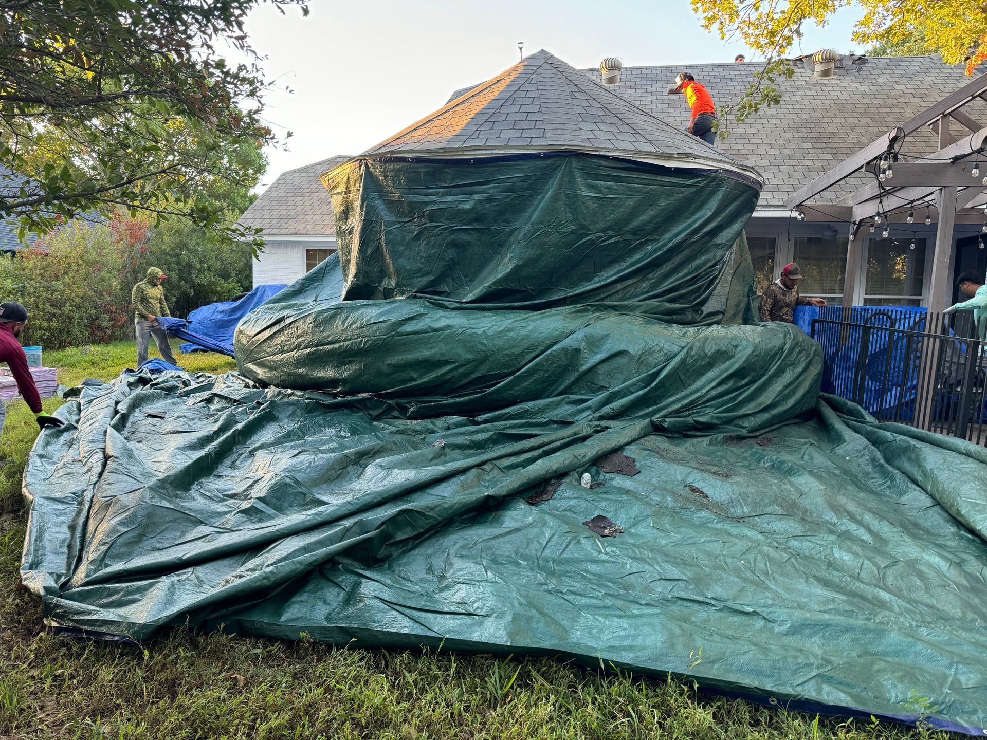 Night 'N' Day Construction tarping the exterior of a home in Fort Worth, Texas, preparing for a residential roof removal and replacement as part of an insurance claim