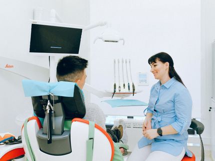 patient talking with dental assistant while patient is sitting in dental chair