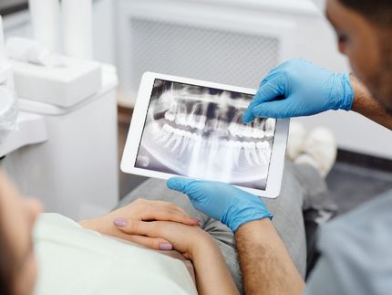 patient sitting with dentist reviewing xray scans