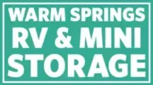 Warm Springs RV & Mini Storage sign in white text on a turquoise background.
