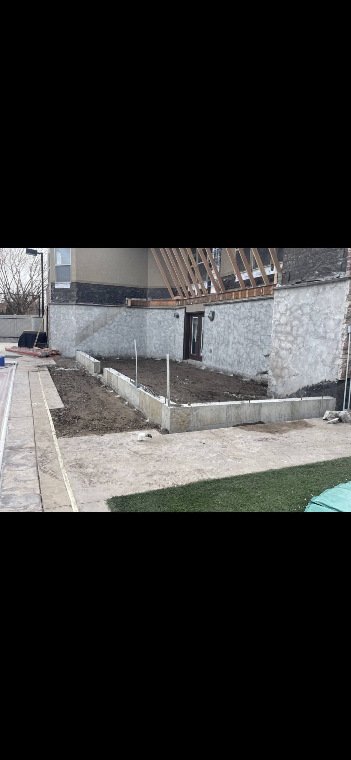 A freshly poured concrete driveway in a suburban neighborhood under a partly cloudy sky. A freshly poured concrete driveway in a suburban neighborhood under a partly cloudy sky.