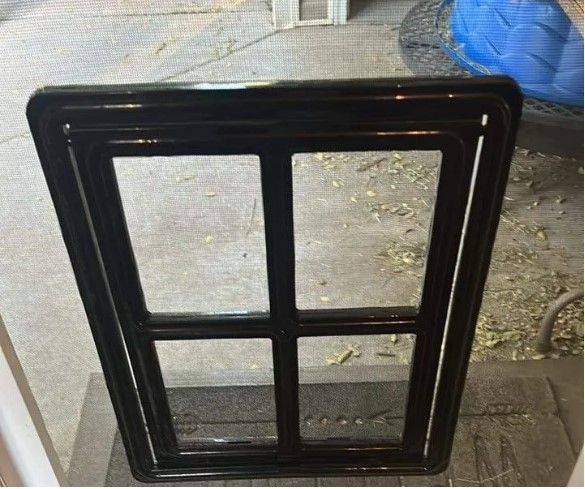 A black window frame is sitting on a table.