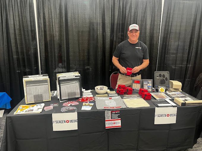 A man is standing in front of a table with a lot of items on it.