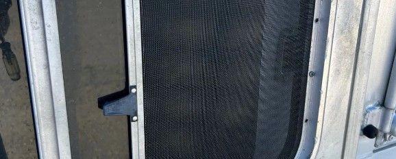A close up of a screen door on a boat.
