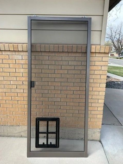 A screen door with a dog door attached to it