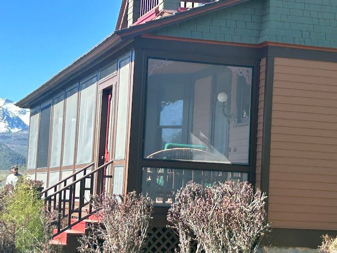 A house with a screened in porch and stairs leading up to it.