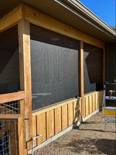 A screened in porch with a ladder in front of it