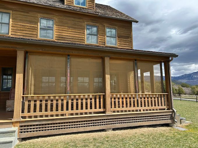 A large wooden house with a screened in porch.