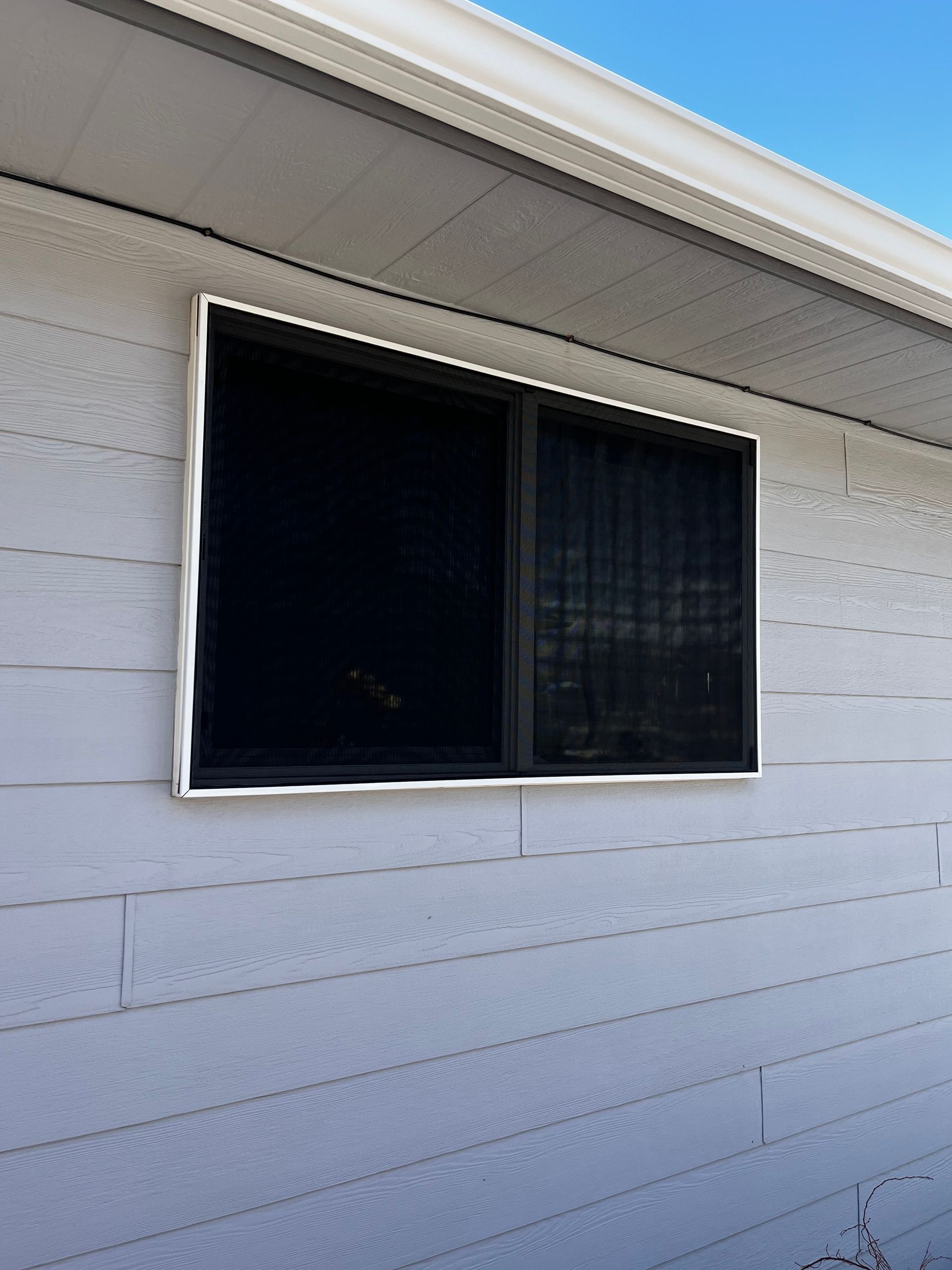 A white house with a black window on the side