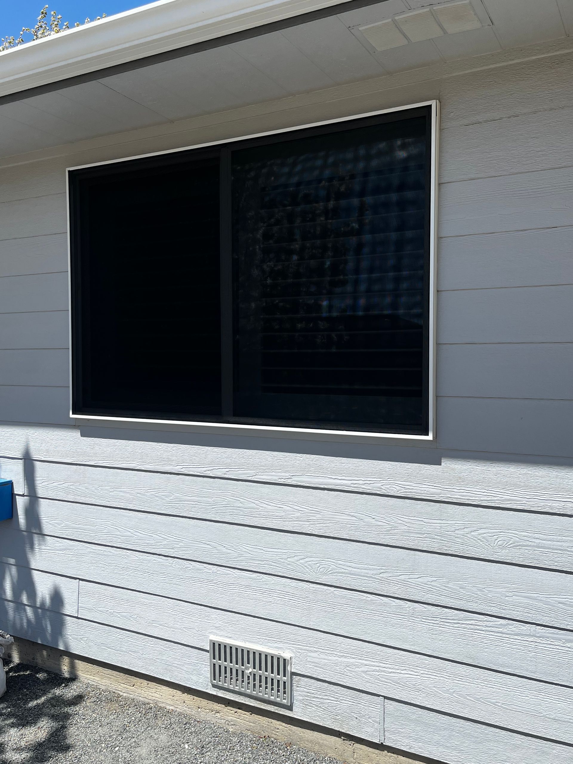 A white house with a large window on the side of it.