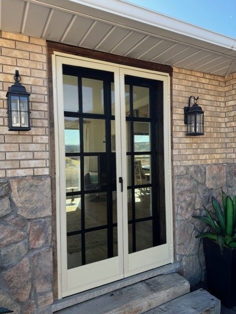 A brick house with a white door and black windows