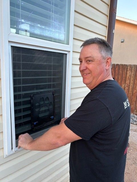A man in a black shirt is opening a window