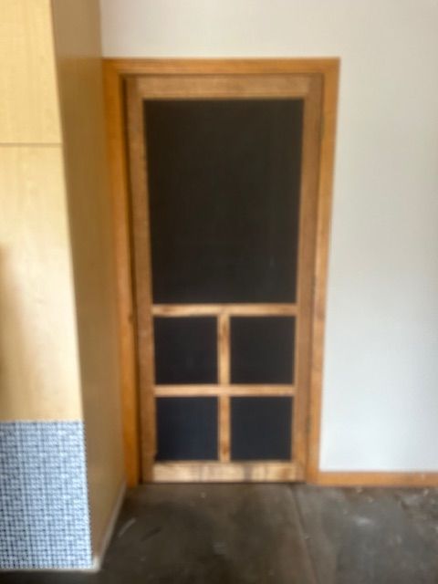 A wooden door with four squares on it in a room.