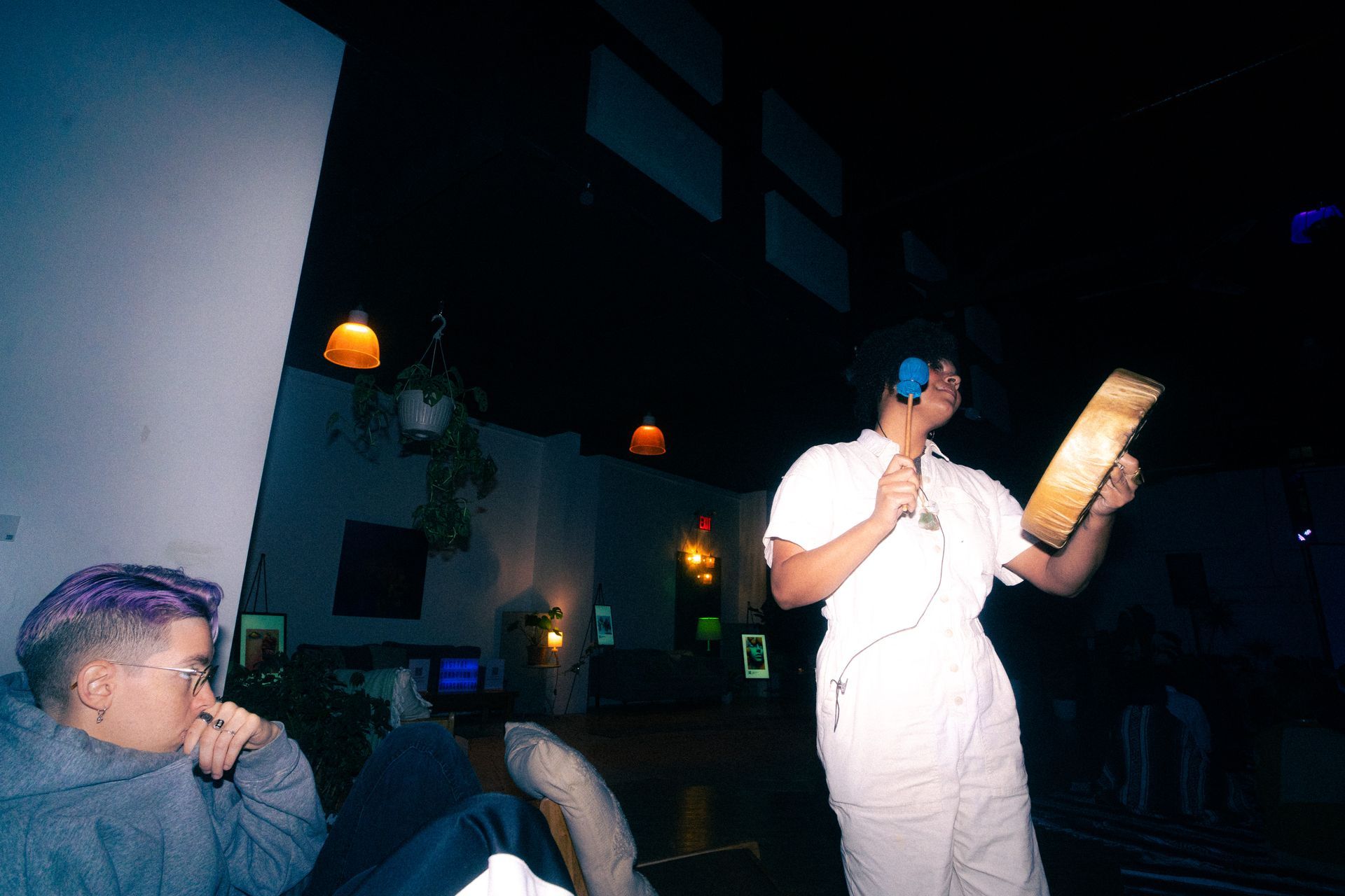 Person with headphones holds a wooden clipboard, speaking.