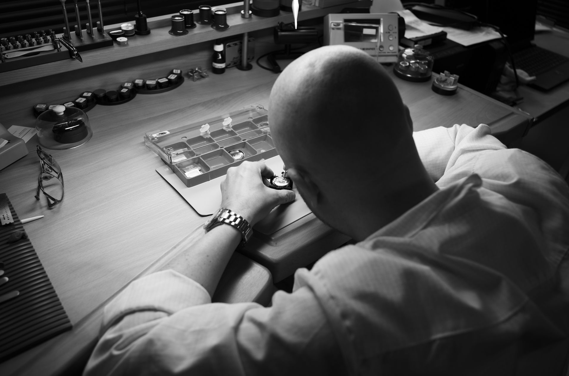 een horlogemaker van em watch service voort een horloge reparatie uit