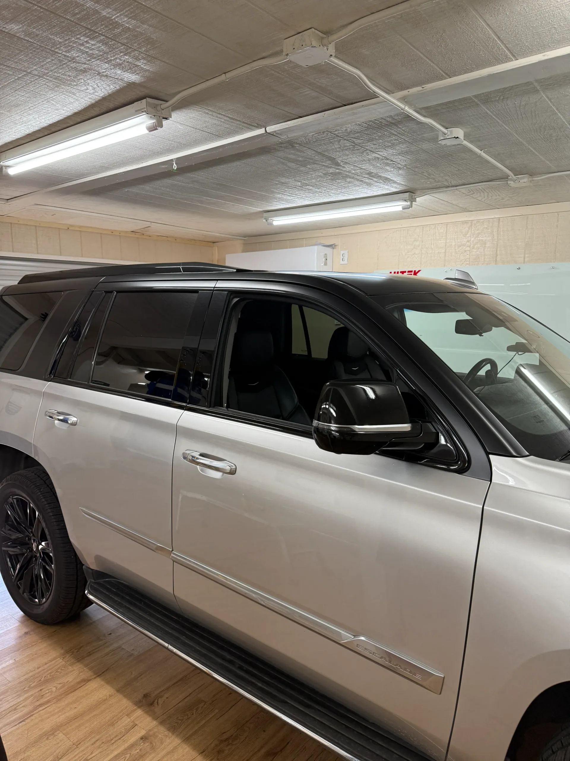 Silver SUV with black trim and tinted windows parked indoors.