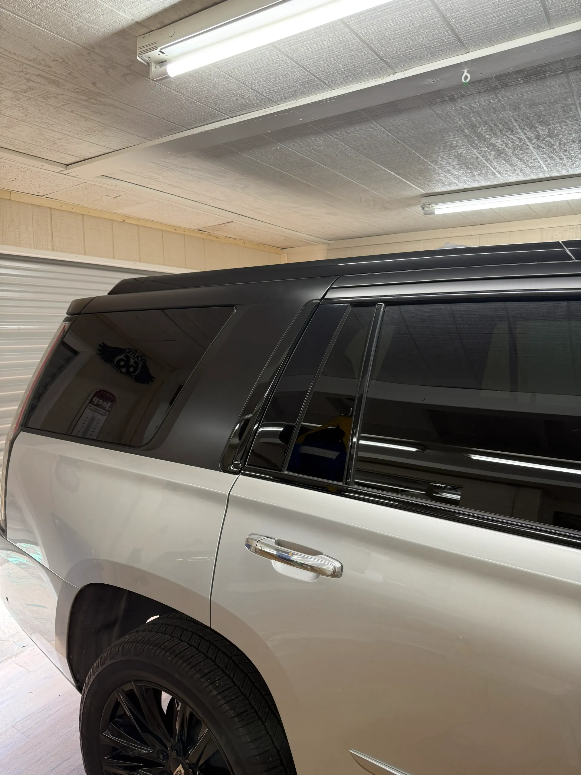 Silver SUV with black tinted windows and black rims.