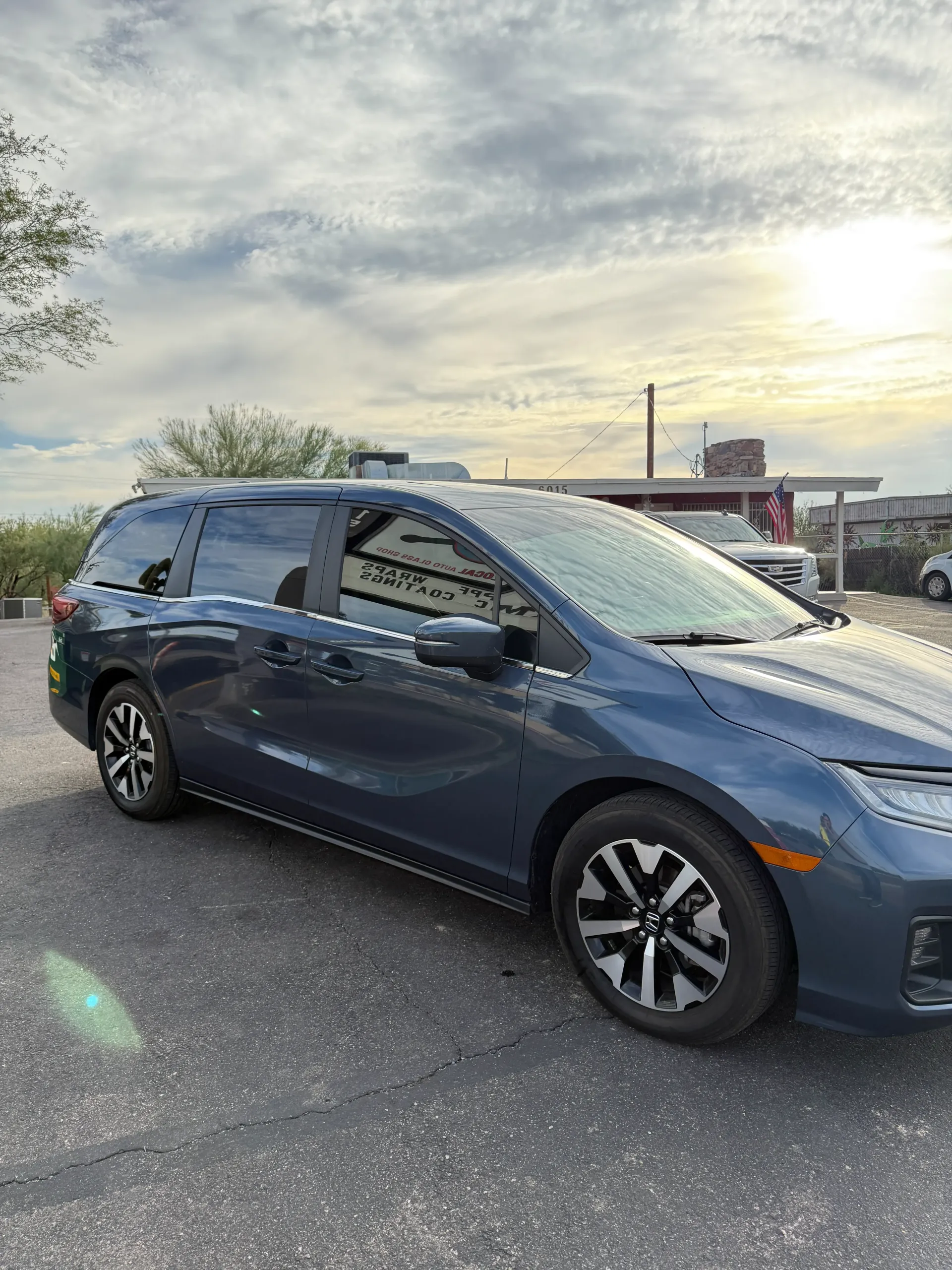 Blue Honda Odyssey minivan parked on asphalt in an outdoor setting.