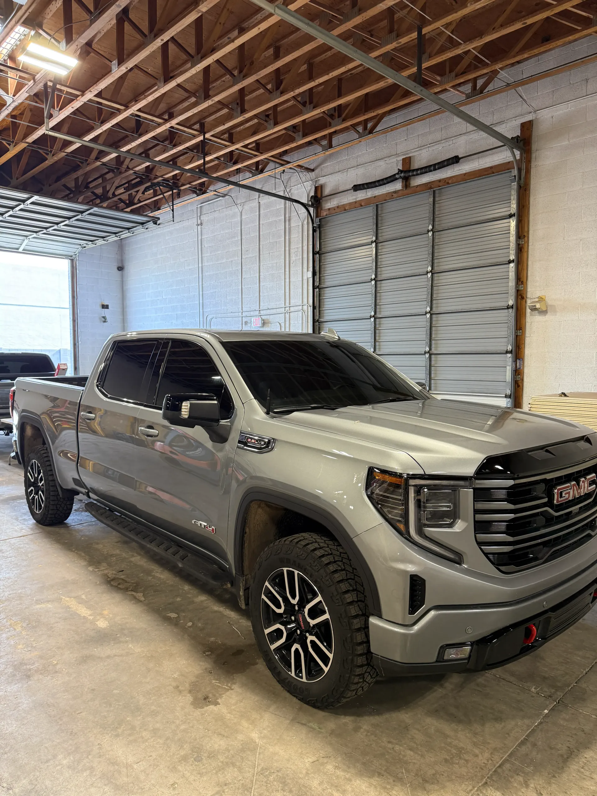 Gray GMC Sierra pickup truck parked inside a garage.