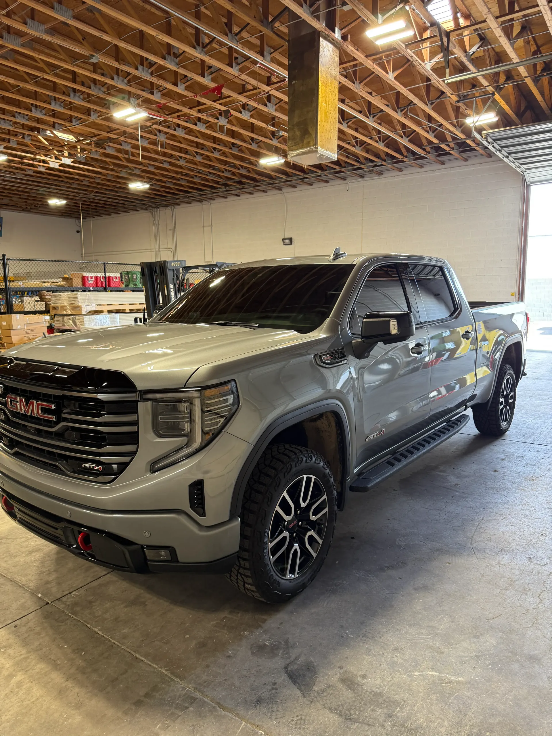 Gray GMC Sierra pickup truck parked inside a warehouse.