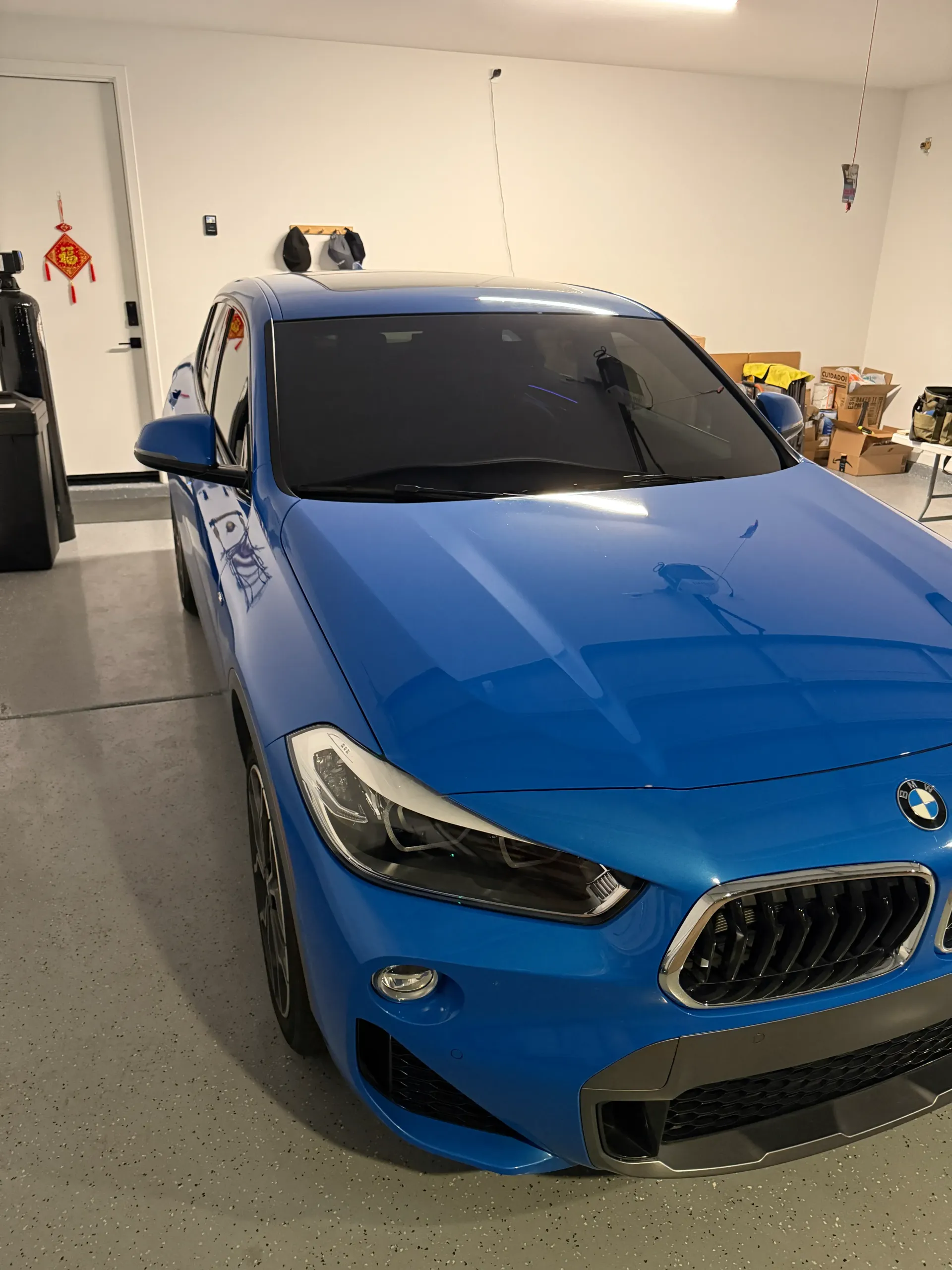 Blue BMW SUV parked in a garage.