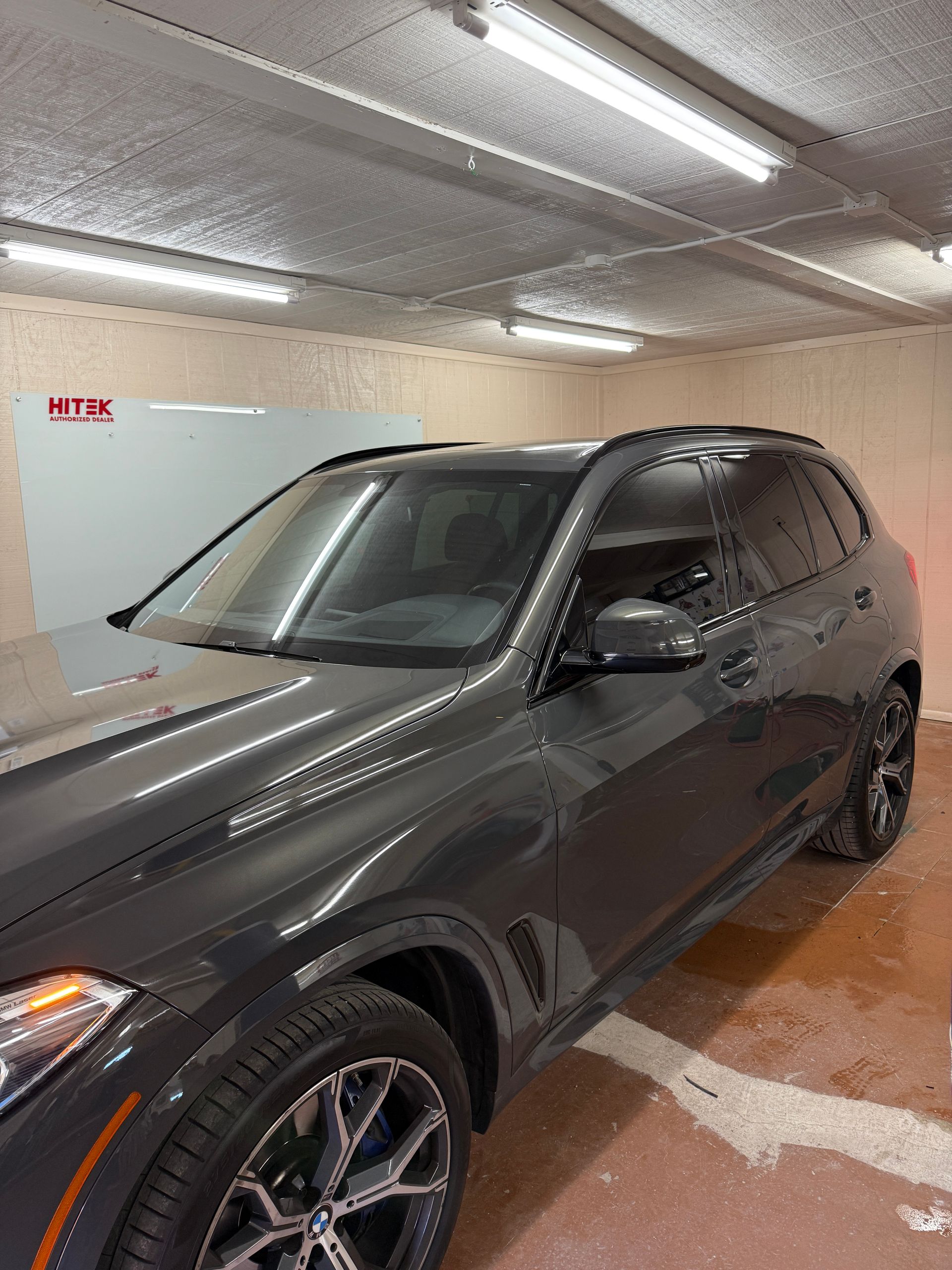 Gray BMW SUV parked in a garage.
