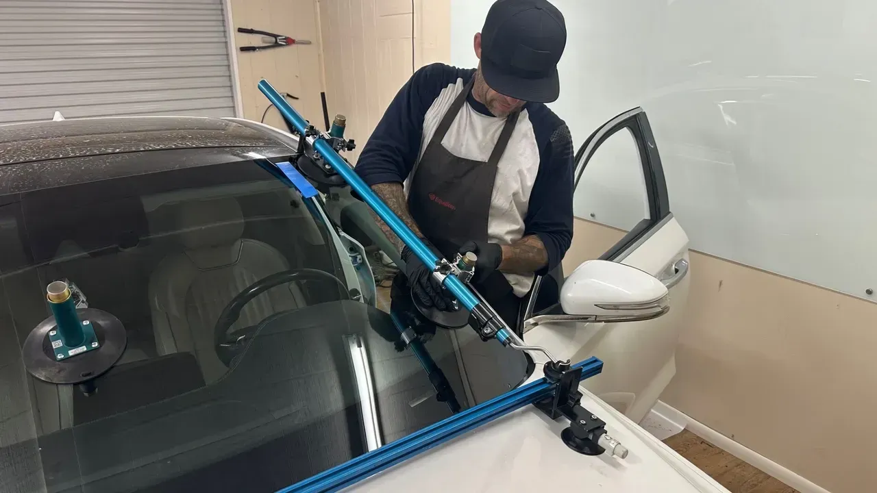 White lifted Ram pickup truck inside a garage with bright hexagon lights overhead.
