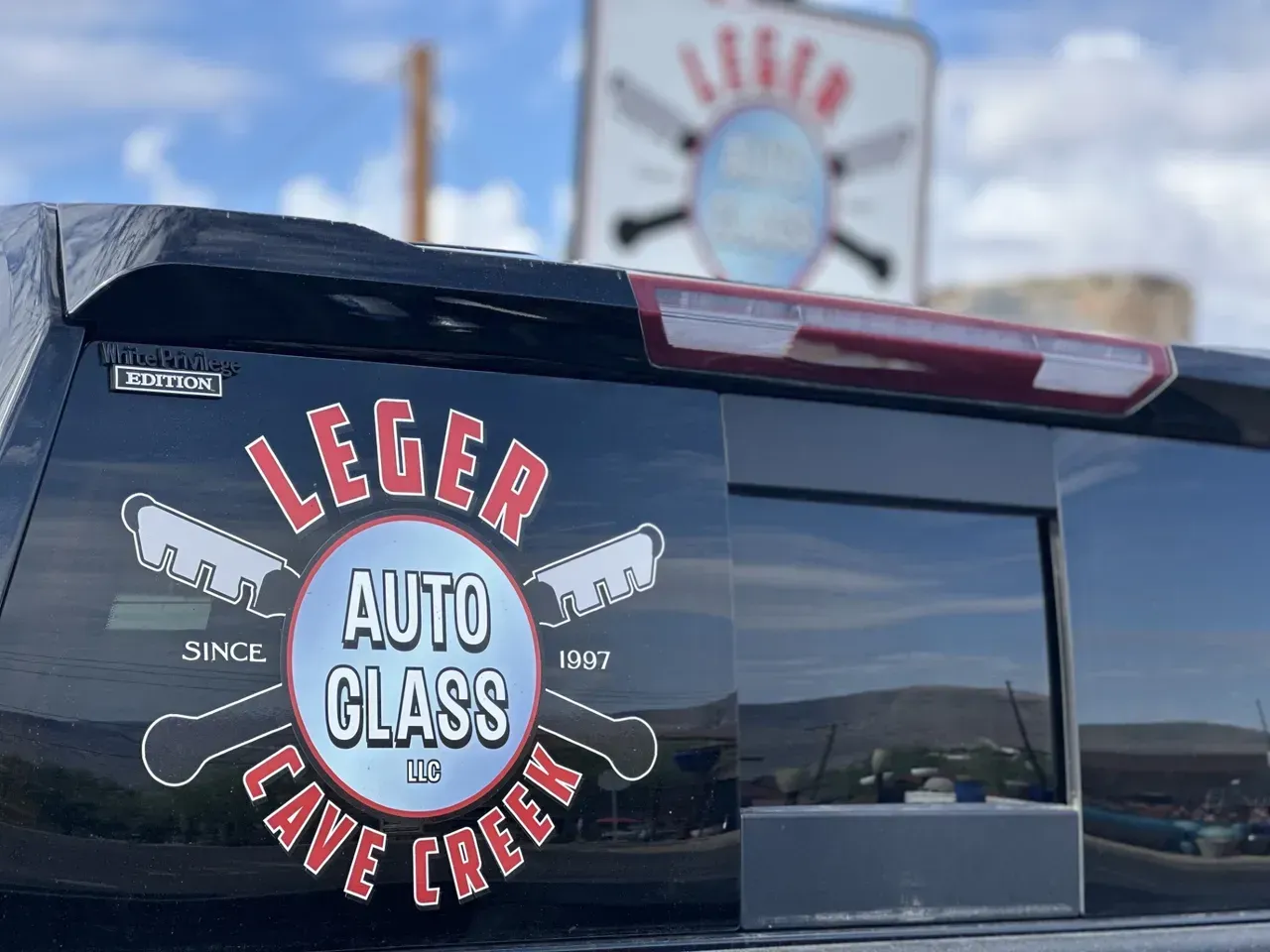 White lifted Ram pickup truck inside a garage with bright hexagon lights overhead.